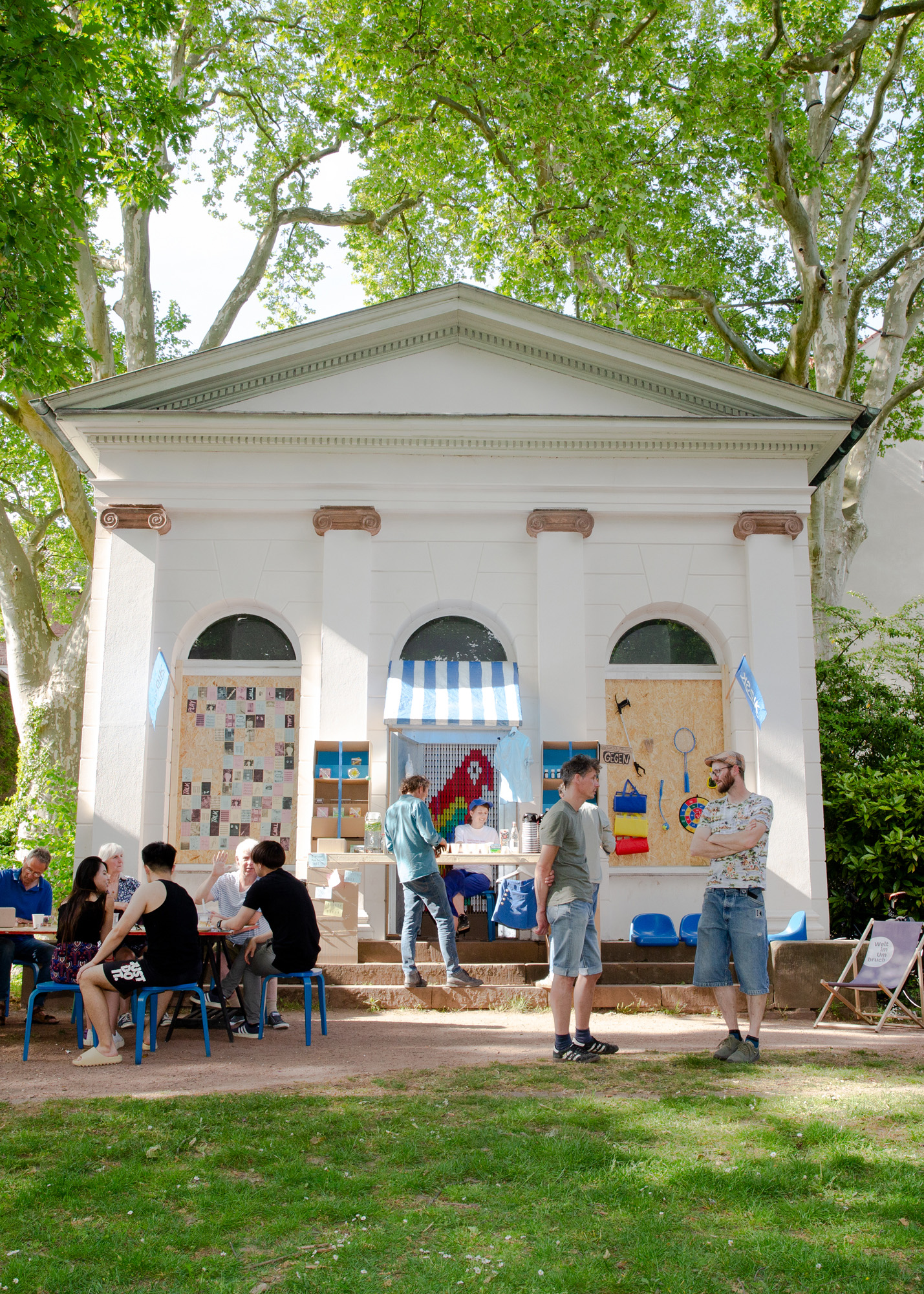 Menschen stehen vor einem Steinpavillon im Sommer